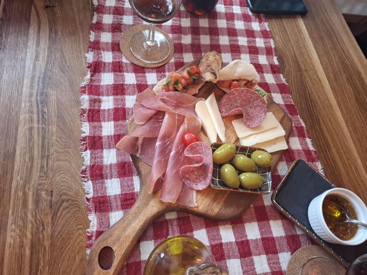 Antipasti-Brett mit Schinken, Salami, Käse, Oliven und Bruschetta