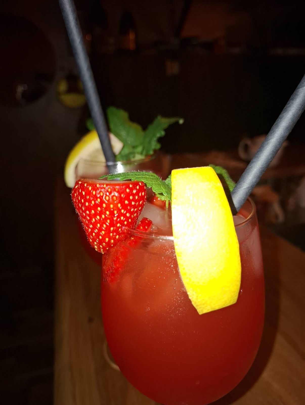 Roter Cocktail mit Erdbeere, Zitrone und Minze