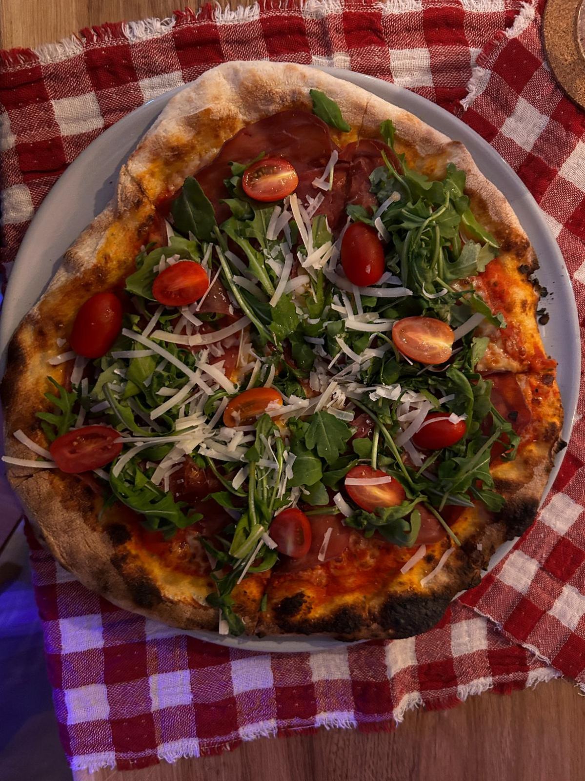 Pizza Rucola & Bresaola auf kariertem Tischtuch