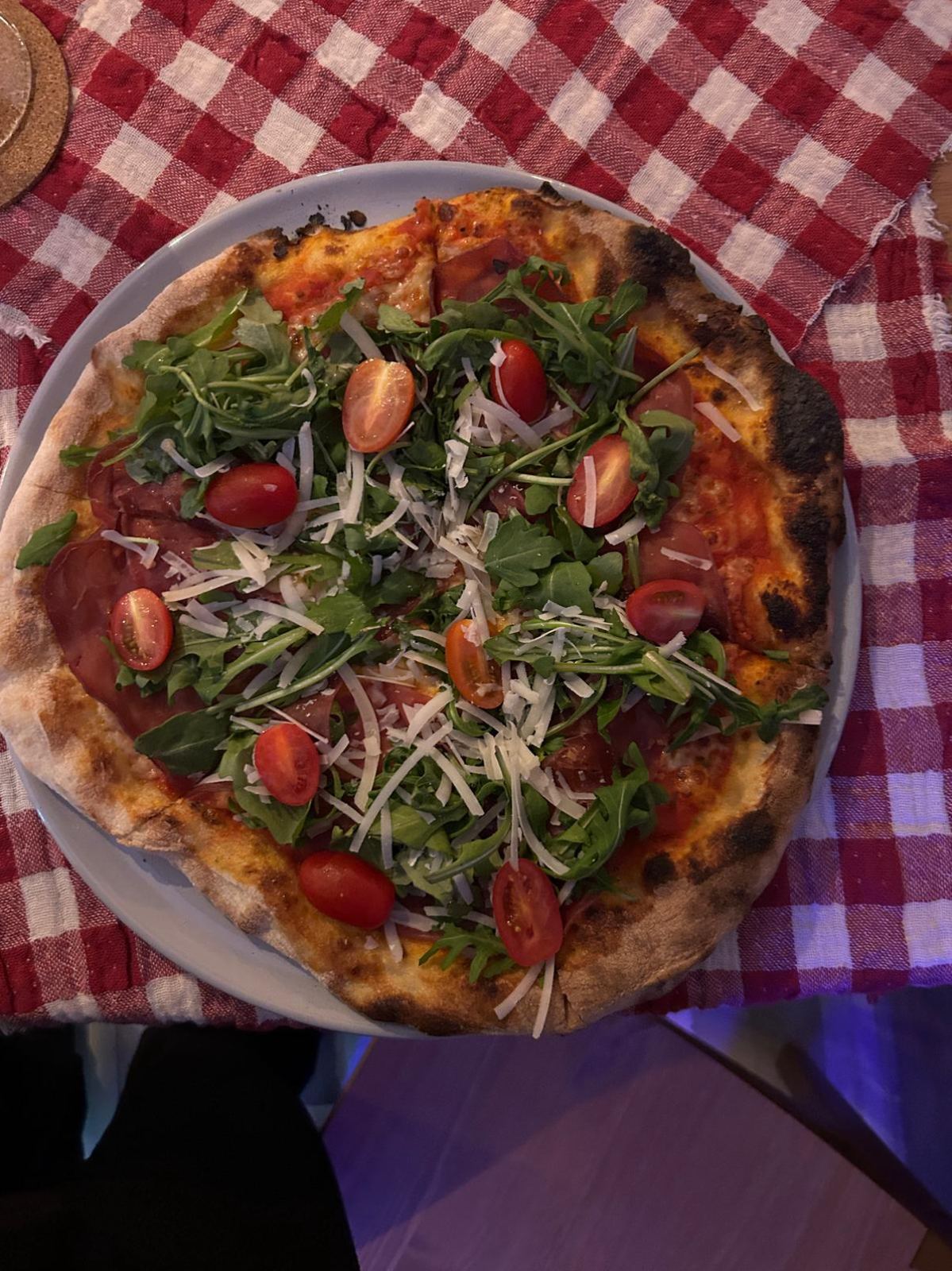 Pizza mit Rucola, Cherrytomaten, Parmesan und Bresaola